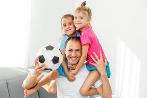 en familj av fläktar tittar på en fotboll match på TV på Hem foto