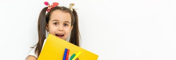 porträtt av leende skola flicka barn med ryggsäck och böcker isolerat på en vit bakgrund foto