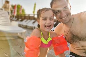 Lycklig familj far och hans förtjusande liten dotter på utomhus simning slå samman framställning selfie foto