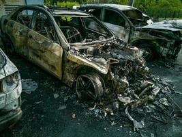 bränt bil. uppsättning brand till bilar i parkering massa. bandit krig, de förstörelse av de brand maskin efter de molotov cocktail. deformerad brand maskin. konsekvenser av bil olycka. skadad förbi mordbrand foto