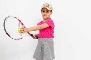 brunett liten flicka med en tennis racket isolerat på en över vit bakgrund foto