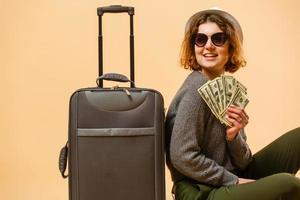 stänga upp turist kvinna i sommar tillfällig kläder, hatt på resväska pass kontanter pengar isolerat på gul bakgrund. passagerare reser utomlands till resa på helger flykt. luft flyg begrepp foto