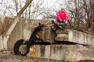 en liten flicka är dölja från en hund foto