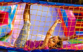 liten barn Hoppar på trampolin i inomhus lekplats. aktiva litet barn flicka har roligt på sport Centrum foto