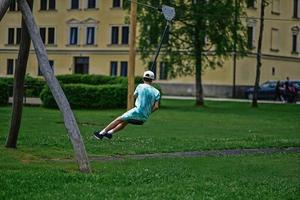 pojke svängande på rep på lekplats. foto