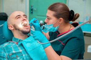 manlig modell behandlar tänder i dental kontor foto