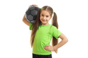 glad liten flicka leende med fotboll boll i henne händer foto