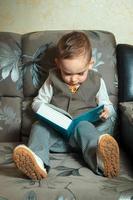 ung pojke läsa en bok foto