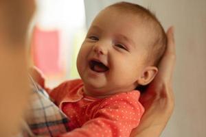 Lycklig liten bebis flicka ler foto