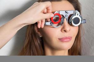 härlig flicka checkar syn i ett ögonläkare med korrigerande linser foto