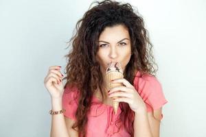 allvarlig ung kvinna äter is grädde kon foto