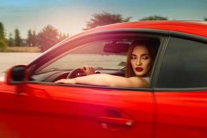 glamour ung kvinna körning en bil foto