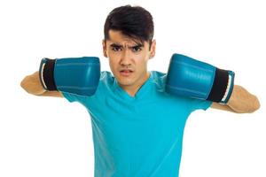 ung arg man i blå skjorta praktiserande boxning i handskar isolerat på vit bakgrund foto