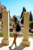 ung flicka nära de ruiner av gammal grekland foto