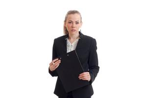 sexig blond i ett kontor kostym utseende ett huvud och innehav en svart läsplatta foto