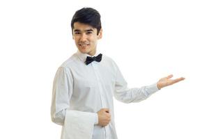 ung vänlig servitör ler och sträckor mot de hand foto