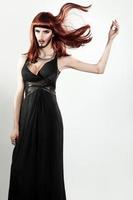 sensuell shemale modell med smink och röd Färg hår i studio foto