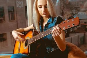 närbild Foto av skön kvinna med gitarr i henne händer