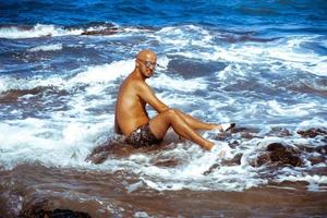 sexig man på de marin klippig Strand foto