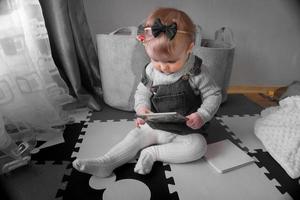 sötnos liten bebis flicka ser en bok foto
