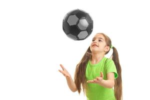 glad liten flicka spelar med boll i studio foto