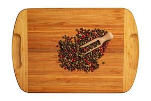 trä- mat bakgrund med kryddor. en blandning av paprikor med en trä- sked på en kök styrelse. foto