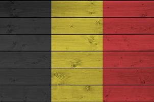 belgien flagga avbildad i ljus måla färger på gammal trä- vägg. texturerad baner på grov bakgrund foto