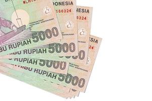 5000 indonesiska rupiah räkningar lögner i små knippa eller packa isolerat på vit. attrapp med kopia Plats. företag och valuta utbyta foto