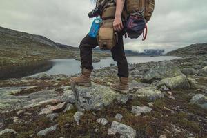 vandrare stående på sten nära smal flod naturskön fotografi foto