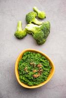 färsk broccoli chutney eller klistra, puré i de skål med rå bitar foto
