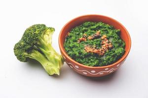 färsk broccoli chutney eller klistra, puré i de skål med rå bitar foto