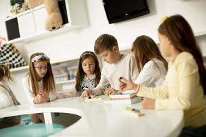 grupp av söt liten barn spelar med förskola pedagogisk leksaker foto