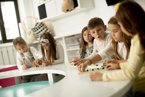 grupp av söt liten barn spelar med förskola pedagogisk leksaker foto