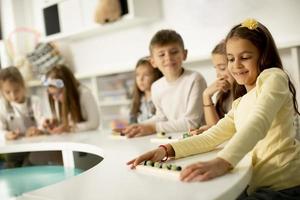 grupp av söt liten barn spelar med förskola pedagogisk leksaker foto