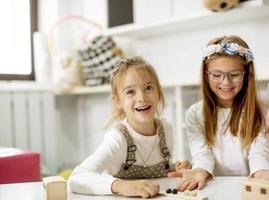 två söt liten flickor spelar med förskola pedagogisk leksaker foto