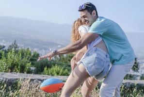 par spelar amerikan fotboll på varm sommar dag. par spelar rugby Foto skjuta