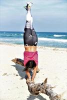 passa sportig kvinna praktiserande akrobatisk yoga på de strand foto
