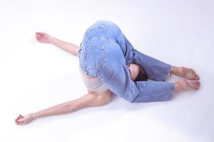 porträtt av skön ung kvinna med atletisk flexibel kropp håller på med ben stretching. isolerat foto