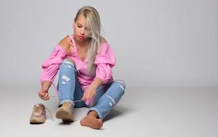 porträtt av skön ung kvinna i söt rosa skjorta och blå jeans Framställ i studio. begrepp av skönhet, känslor, ansiktsbehandling uttryck, livsstil, mode, ungdom kultur foto