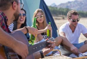 grupp av vänner har roligt utanför tält på camping Semester foto