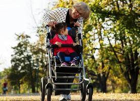 mormor och henne autistisk stor dotter njuter Semester tillsammans utomhus, liggande på grön gräs på filt och leende till kamera. fritid familj livsstil, lycka och ögonblick. foto