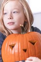 Lycklig blond pojke träsnideri pumpa för halloween. halloween begrepp foto