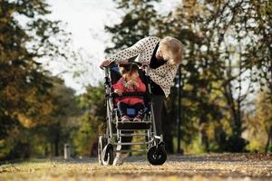 mormor och henne autistisk stor dotter njuter Semester tillsammans utomhus, liggande på grön gräs på filt och leende till kamera. fritid familj livsstil, lycka och ögonblick. foto