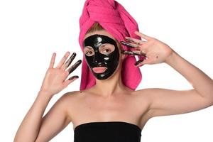ung skön kvinna med en mask för de ansikte av de terapeutisk svart lera foto