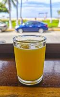 glas av orange juice på trä- tabell puerto escondido Mexiko. foto