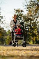 mormor och henne autistisk stor dotter njuter Semester tillsammans utomhus, liggande på grön gräs på filt och leende till kamera. fritid familj livsstil, lycka och ögonblick. foto