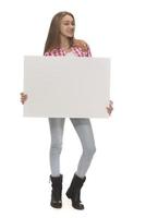 ung leende kvinna innehav en tom ark av papper för reklam foto