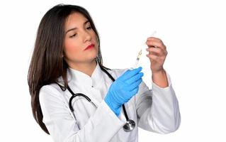 en ung kvinna läkare med stetoskop framställning en injektion, isolerat på vit bakgrund foto