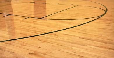 interiör av tömma modern basketboll inomhus- sport domstol, halvmatt beläggning trä- golv, artificiell lampor reflekterad foto
