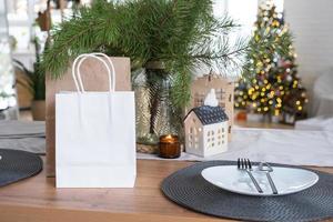 papper paket falsk upp är på kök eras tabell dekorerad för jul. handla och gåvor, närvarande och redo måltider är levereras och beredd för de ny år foto